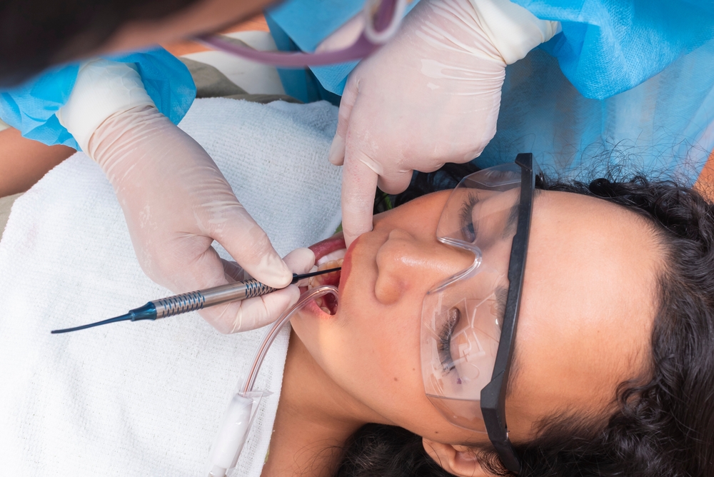 A close-up of a woman's bright smile, showcasing her white teeth and joyful expression.
